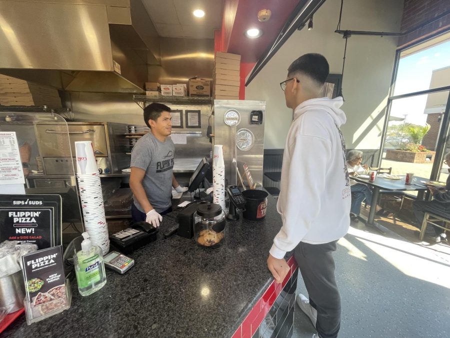 Flippin Pizza employee takes orders from students during lunch.
