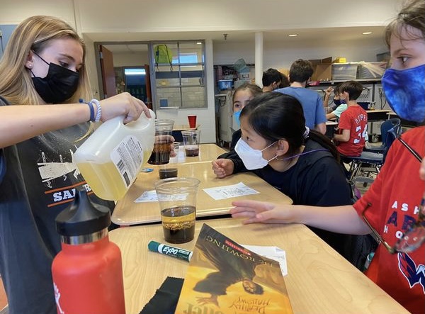 Junior Kate Kristle pours oil into cups for students, as they make their own lava lamps. One of KAST clubs main goals with the donation was to help with purchasing materials. Prior to the donation, materials were purchased by club members.