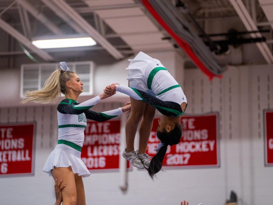 Senior captains Ava Franke and Gianna Relacion fly in the air at the county competition at Montgomery Blair High School on Oct. 29. WJ cheer had many stunts that sent their cheerleaders flying in the air at this competition.
