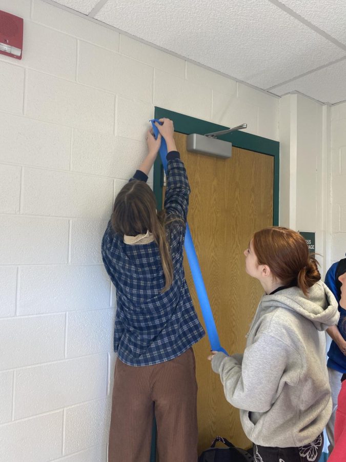 Natalie Zaid (right) and Molly Scanlon (left) the co-treasurers of Uplift WJ place tape up on the walls of the new Wellness Room in order to begin the painting process. Uplift WJ has allocated funds from the school in order to decorate and furnish the room located behind the counseling office.