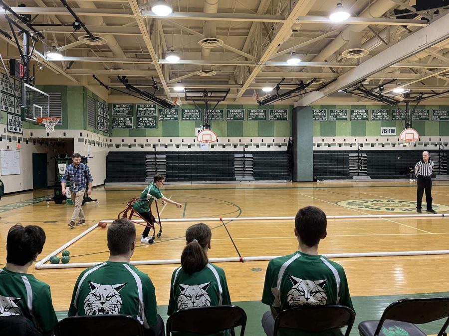 Senior Hannah Albus rolls the ball as her teammates support her. Even after a close game, the team was very proud of their performance.