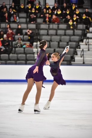 Facing forward, senior Clara Neal skates with a partner during a free skate program and performs a catch foot. She was looking forward to dedicating more time to figure skating since the high school field hockey season is over.