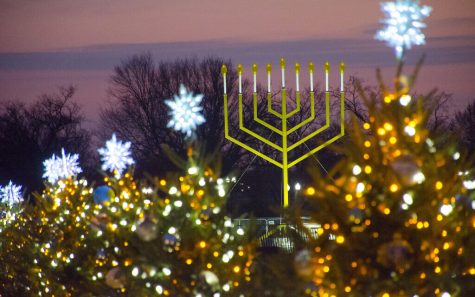 A Hanukkiah (Hanukkah Menorah) perches in the foreground of a cluster of glistening trees. In December, three major holidays are celebrated: Christmas, Hanukkah and Kwanzaa. However, in the past and recently, the US hasnt done a good job in representing the diverse communities of people it prides itself on representing.