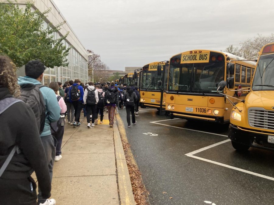 Students walk to their buses at the end of the school day. Thanks to a new bus electrification project, many students now ride electric buses to and from school.