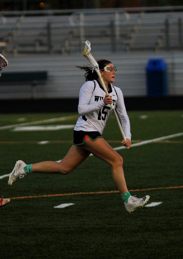 Junior Anna Zucconi sprints down the field in varsity lacrosse game. Zucconi just finished her soccer season and is changing focus to lacrosse.