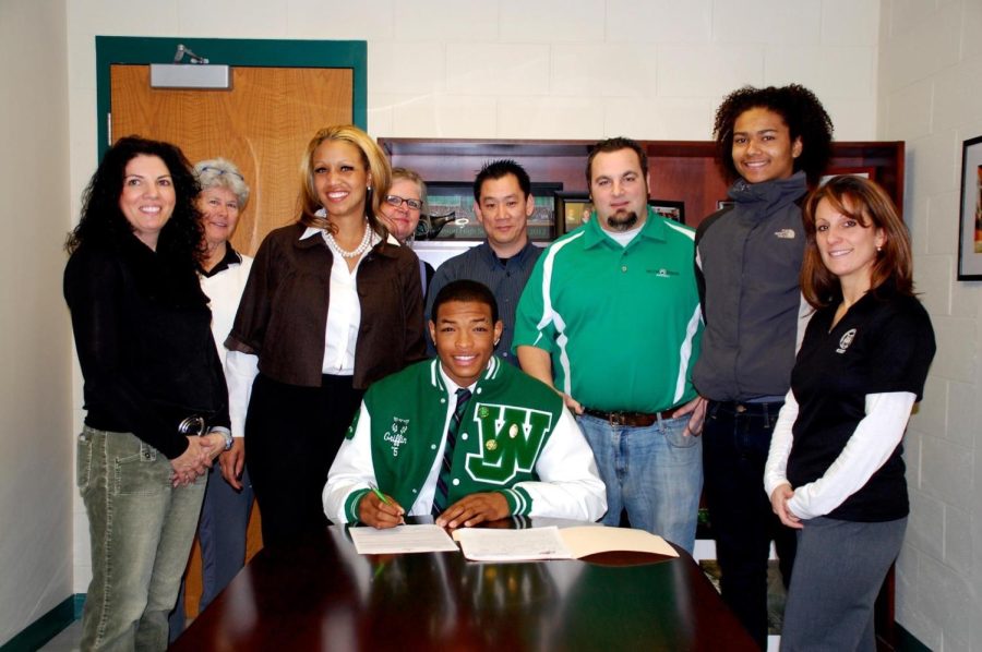 WJ alum Kalaii Griffin II signs to play division I football at the St. Francis PA University. Signing to a division I team was uncommon for the team at the time. (From left: Lisa Sorenson, Sue Amos, Kalena Griffin Costa, Sarah Bieber, Bob Yi, John Kadi, Ezequiel Griffin, Susan Fazio)