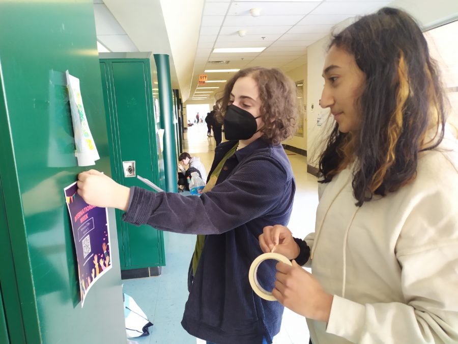 Senior Catherine Seeger and junior Niya Tripathi hang posters promoting International Week. The Student Advisory Board has also reached out to club leaders and staff, and created a morning announcement video to draw more interest in the event.