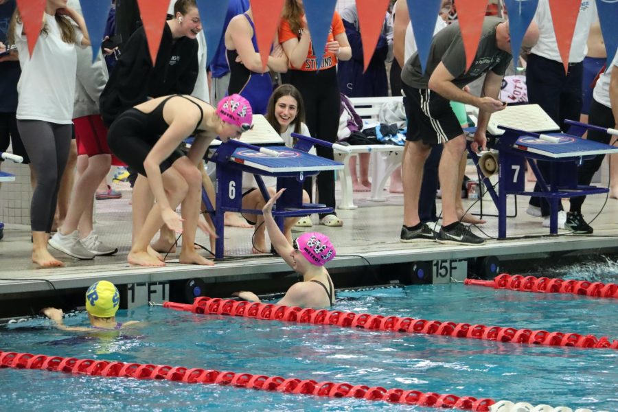 Senior+captain+Sienna+Karp+high+fives+sophomore+Isla+Bartholomew.+The+two+of+them+swam+the+100+breaststroke+next+to+each+other+and+finished+first+and+third.