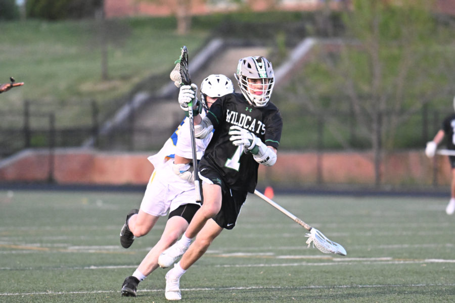 Junior+captain+and+midfielder+JR+Dubose+runs+around+a+defender+in+a+game+against+the+Gaithersburg+Trojans+on+April+19.+The+Wildcats+defeated+the+Trojans+17-10+and+added+more+victories+the+following+week+to+improve+their+record+to+5-4.