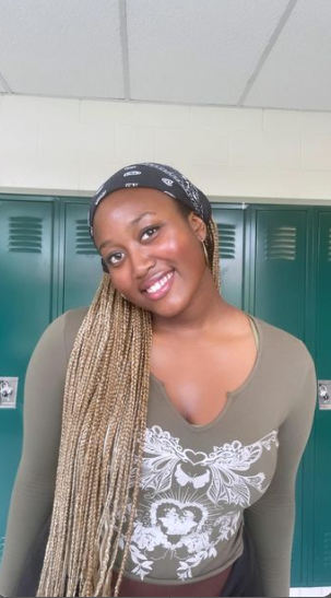 Senior Shiima Nantulya pictured smiling in front of the school lockers.