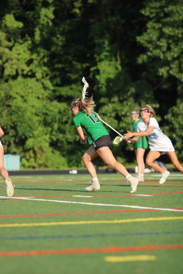 Senior captain and midfielder Ellie Hilton takes the ball down the field. Hilton and the Wildcat offense came together and scored 11 points against the 2023 MOCO Champions.