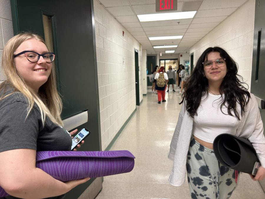 Yoga mats in hand, sophomore Teagan Caine and freshman Kayla Darj walk to the locker room after class.