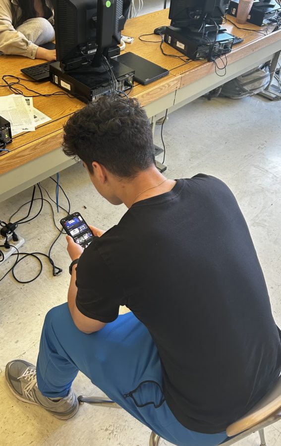 A student checks their phone for updates and numbers for their bets. Online sports betting and other methods of sports betting are prevalent amongst many high schoolers.