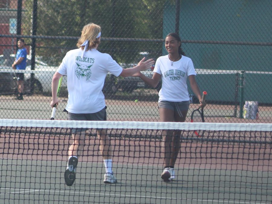 Sophomore Brady MacBride runs to high-five mixed doubles partner junior Sky Carter during the pairs regional final matchup against Wootton. The two won the state mixed doubles title on May 27.