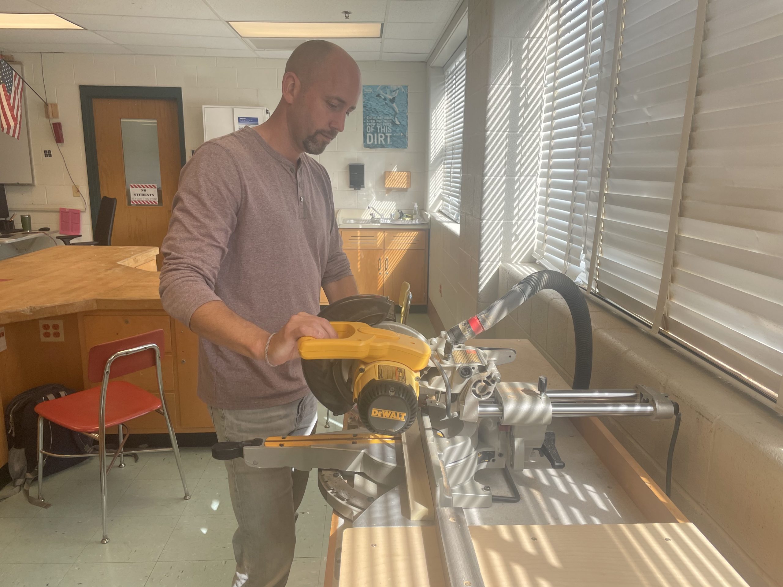 Technology teacher Mike Bauer cuts wood into blocks for an upcoming project using a wood chopper. “We are going to be making cars and racing them down a ramp; should be super fun and I am very excited to get into woodworking with the students, Bauer said.