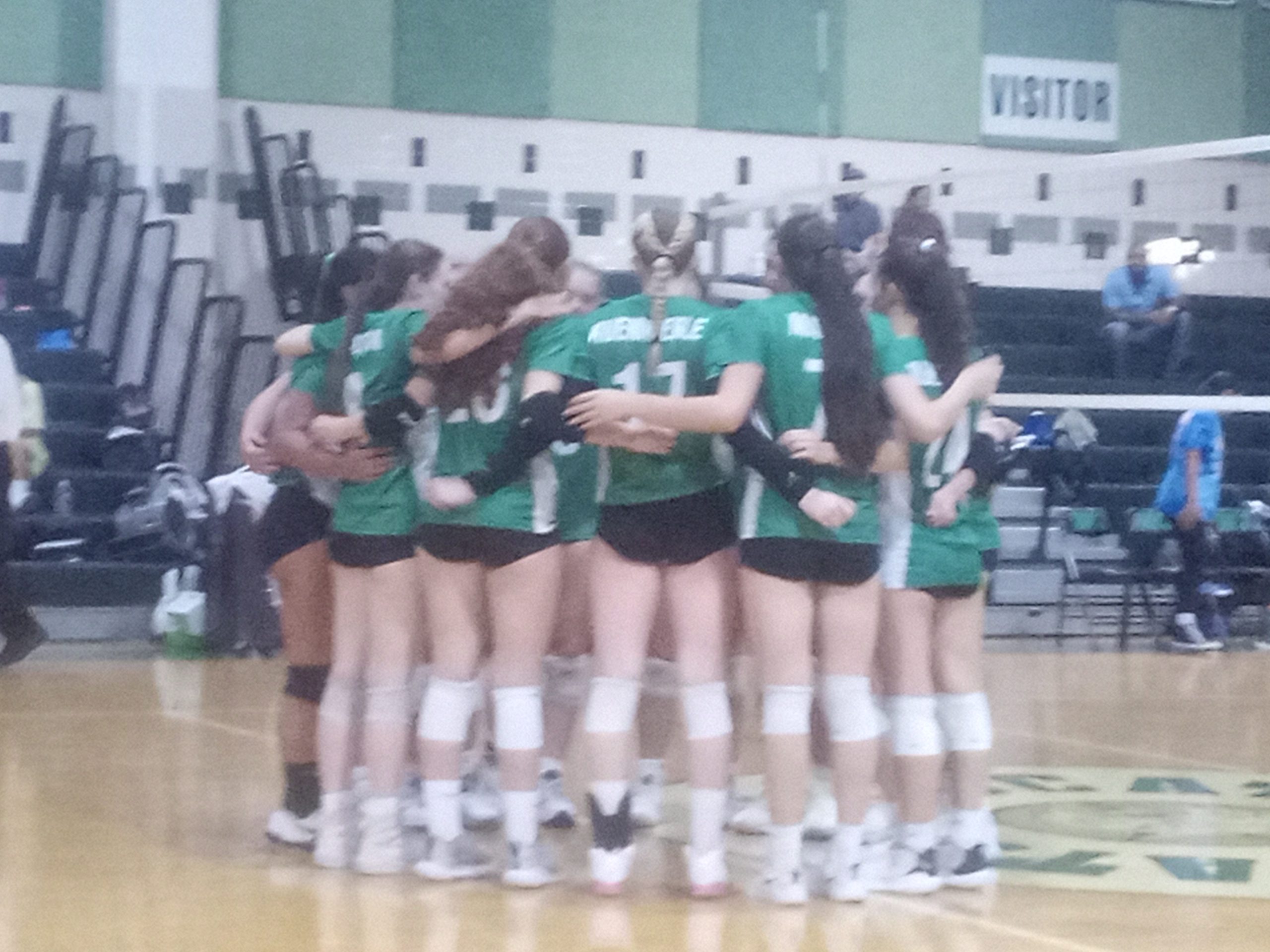 Girls volleyball players huddle in between sets during their first game of the year at home vs Watkins Mill. The team won in a blowout, 3-0.