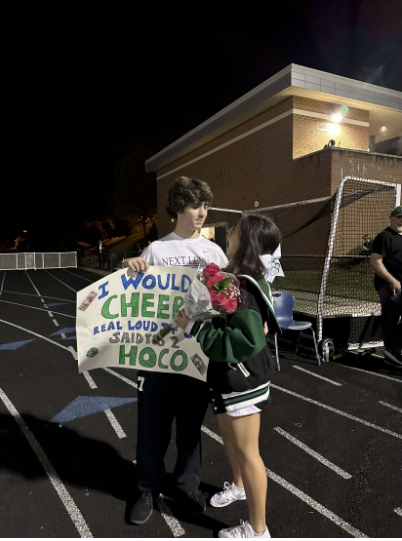 Senior couple Kimmi Shiau and JR Dubose pose for a picture after Dubose asked Shiau to homecoming. Shiau was cheering during the Thursday night football game before Dubose went down to the track to pop the question.