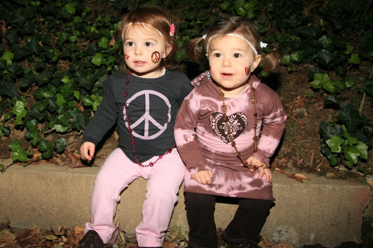 Sasha and Gabby Rappaport sit outside their house on a cold and spooky Halloween night. Dressed in matching hippie costumes and face paint, they easily swooped up the cutest costume award.