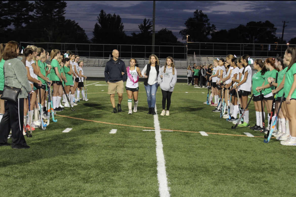 Senior Mary Mercurio walks down the field with her family. Mercurios favorite memories were paddling boarding and team dinners. Mercurio plans to attend college and major in psychology.