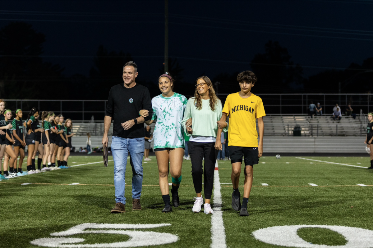 Senior captain Marina Thorn is joined by her family as they walk down the field. Thorn has been playing for the varsity Wildcats for four years and got to celebrate her commitment to the program.