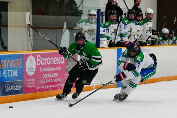 Icecats alternate captain senior Jon Corwin moves with the puck as Churchill senior forward Dalton Esko-Himmelfarb skates in pursuit. Corwin scored a crucial goal with less than two minutes left to bring the Icecats within one goal of the Bulldogs.