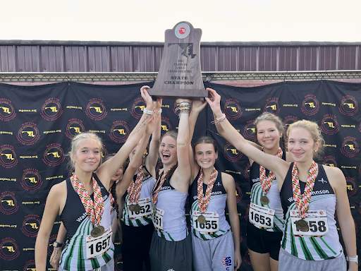 Girls Cross Country celebrates their 1-point win at States over Frederick High School on the first place podium.