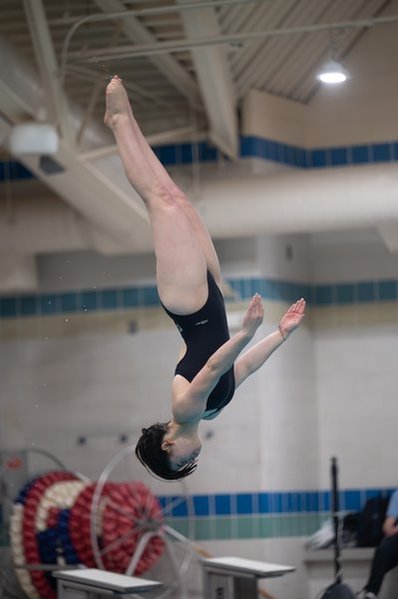 Senior Paulina Horowitz does a back somersault in the straight position into the water.  At practice we have been working on upgrading consistency throughout the season to maintain our 5-0 streak, said Horowitz.