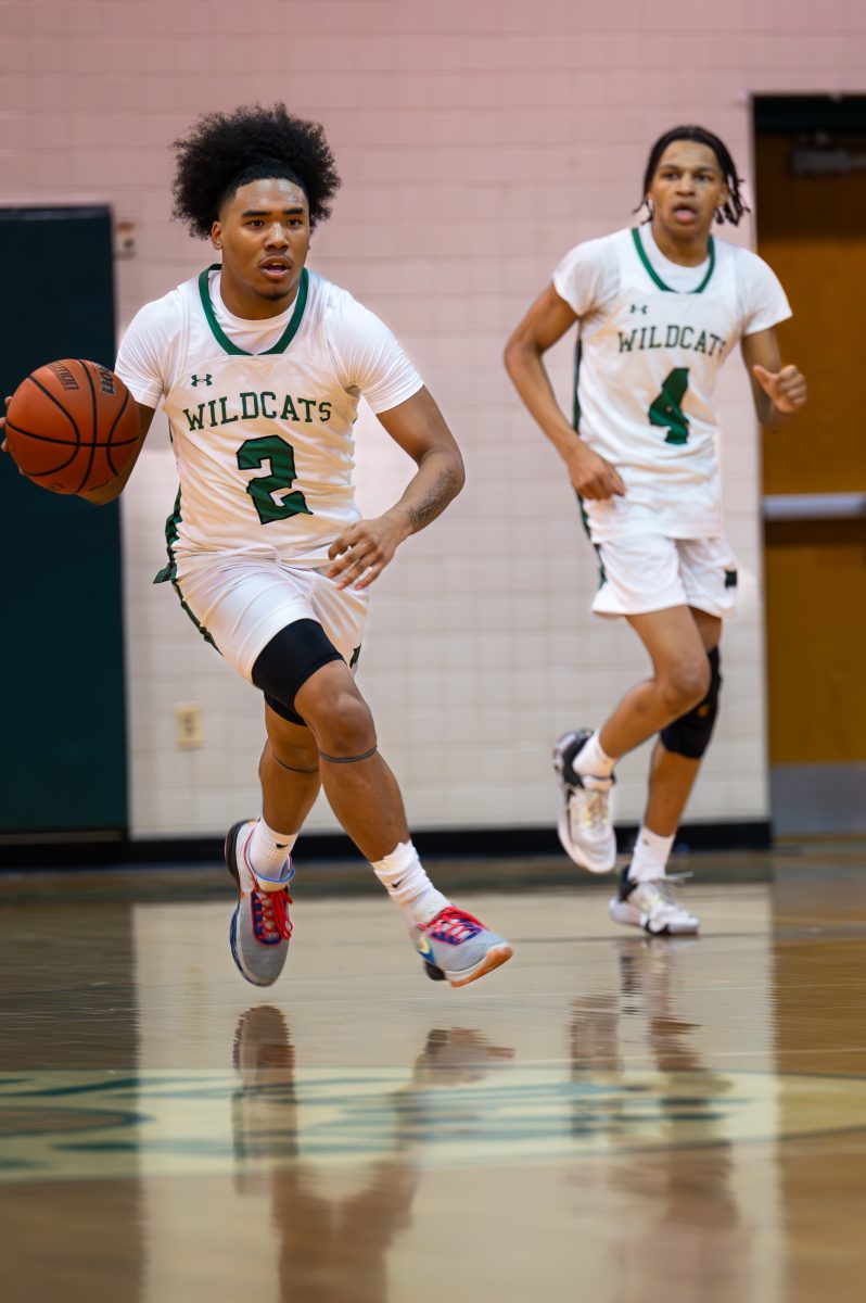Senior guard Isaiah Nickelson (left) sets up the Wildcats offense against Northwest on Friday, Jan. 26. Nickelson scored a clutch basket in overtime to take a one point lead while senior guard Tyrese Rucker (right) grabbed a rebound on the following Jaguars possession before making an assist to seal the game.