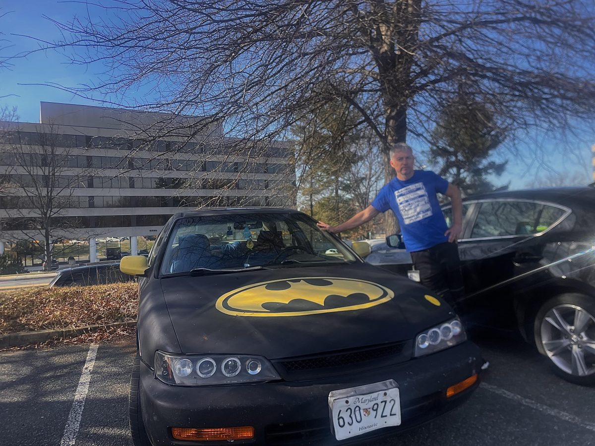 Steven Kerr poses with his homemade Batmobile in the staff parking lot. “We should have more fun with mundane things, Kerr said.