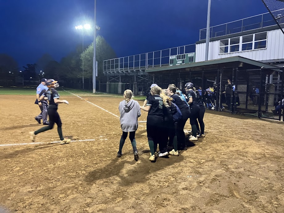 The+Wildcats+gather+around+in+celebration+as+sophomore+catcher+Alina+Bonior+approaches+home+plate+following+her+2+RBI+home+run+in+the+bottom+of+the+third+inning.+Boniors+home+run+was+the+first+by+a+WJ+player+on+the+WJ+field+over+the+fence.
