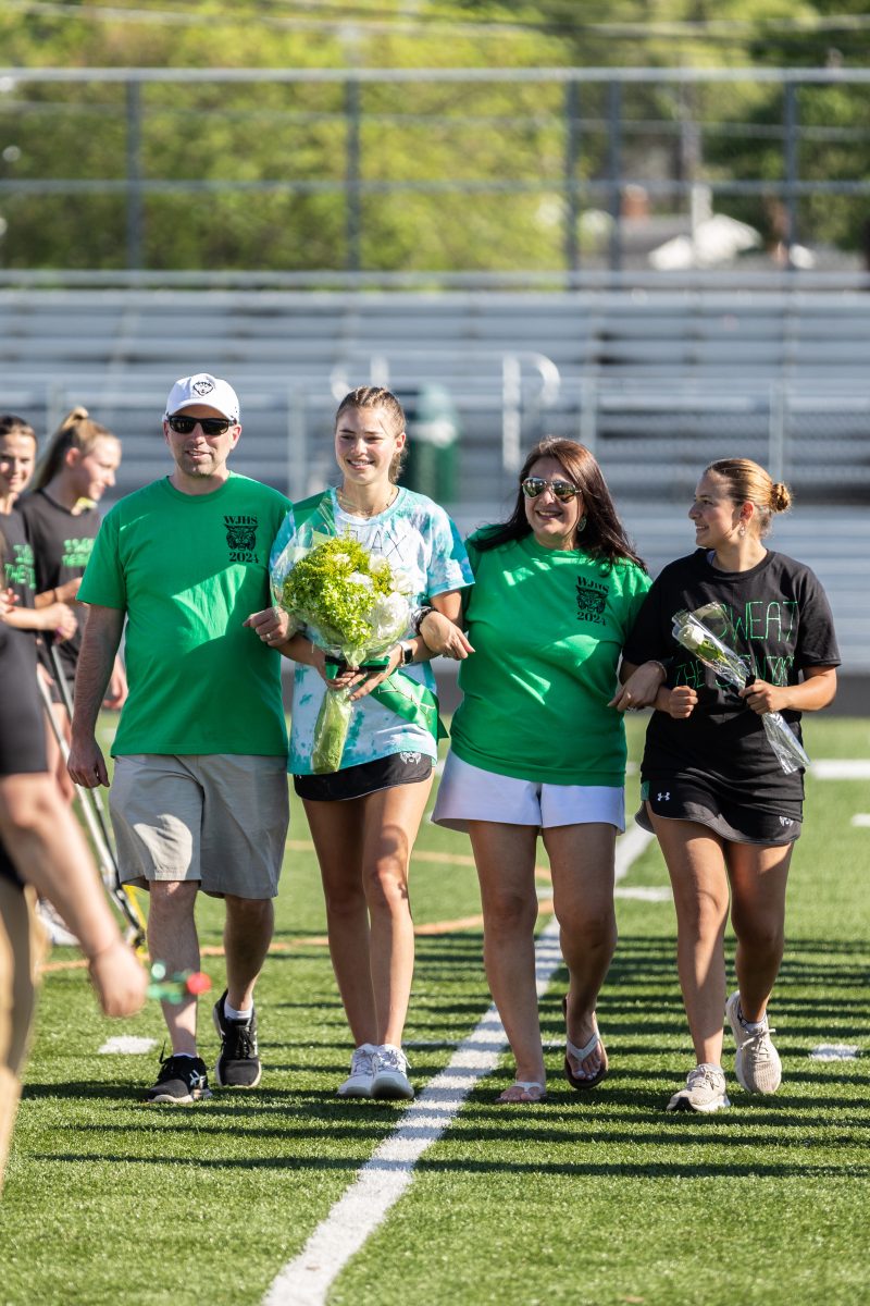 Senior captain Natalya Krouse walks with her family on the Cats senior night on May 1. Each senior was given a bouquet of flowers and was greeted by their coaches at the end of the walk. 
